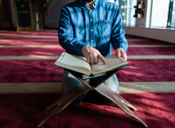 muslim man praying Allah alone inside the mosque and reading isl